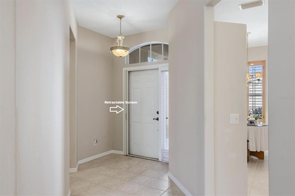 An entryway with tile flooring, a white front door, and a retractable screen door — 8138 VICTORIA FALLS CIRCLE, SARASOTA, FL