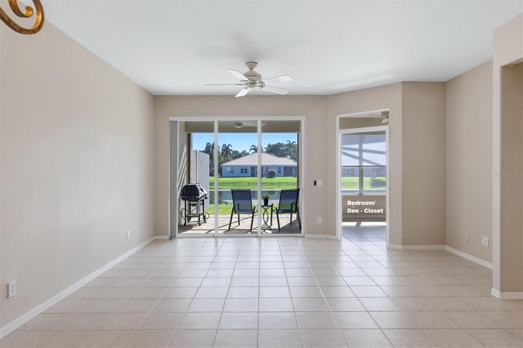 A tiled living area features a ceiling fan, sliding glass doors, and a view of water — 8138 VICTORIA FALLS CIRCLE, SARASOTA, FL