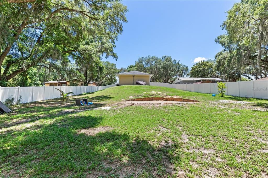 A yellow single-story house with a front-facing garage and a concrete driveway — 206 E CATAWBA, FRUITLAND PARK, FL