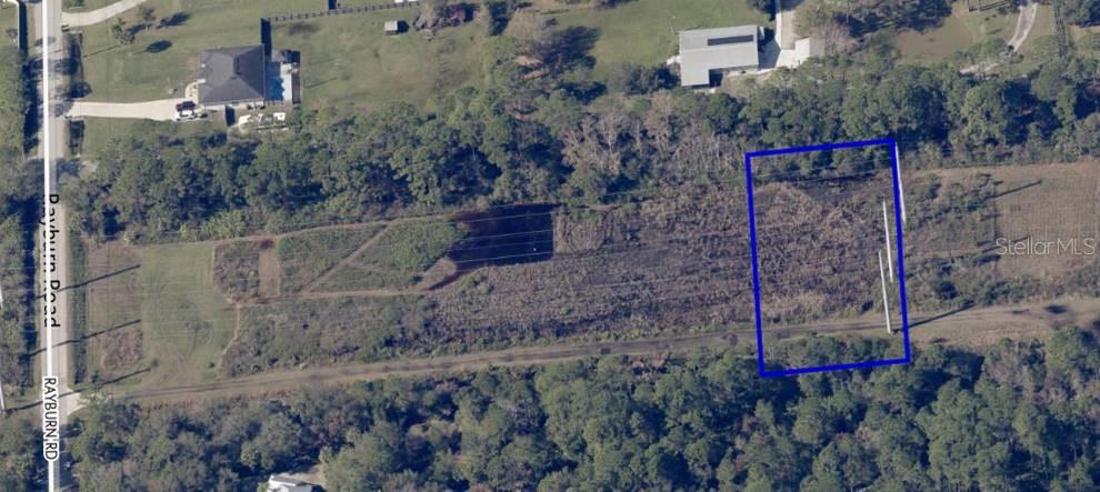 An aerial view shows a rectangular plot of land outlined in blue near a road — TBD RAYBURN ROAD, COCOA, FL