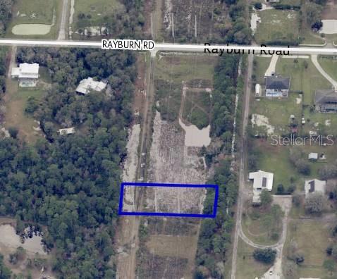An aerial view shows a rectangular plot of land outlined in blue near a road — TBD RAYBURN ROAD, COCOA, FL