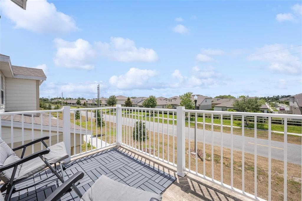 A balcony with a white railing overlooks a suburban street and neighboring houses — 2769 FRANKLIN ROAD, ST CLOUD, FL