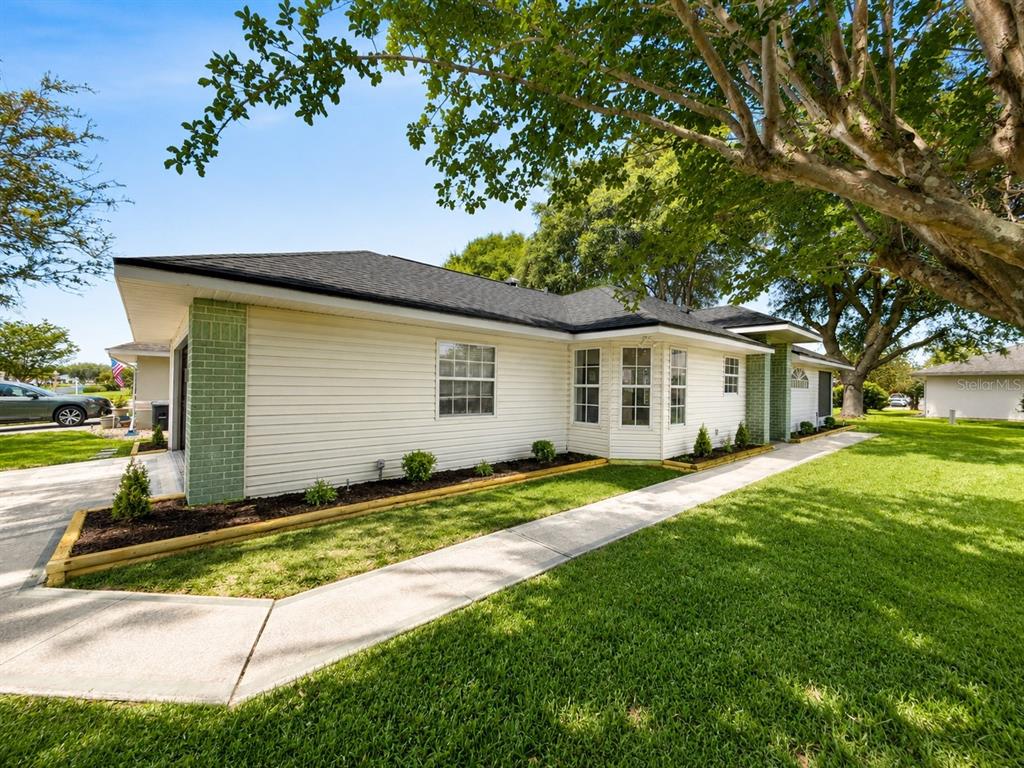 A bright room with light-colored tile flooring, an arched window alcove, and a black chandelier — 5745 KING JAMES AVENUE, LEESBURG, FL