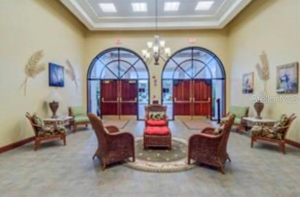 A dining area with light wood-look tile flooring, an arched window alcove, and a black chandelier — 5745 KING JAMES AVENUE, LEESBURG, FL
