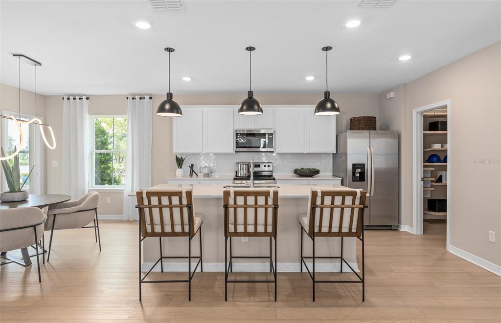 A home office features a round table, an artist's easel, and wall-mounted shelving — 10740 LEAFY LAUREL STREET, ORLANDO, FL