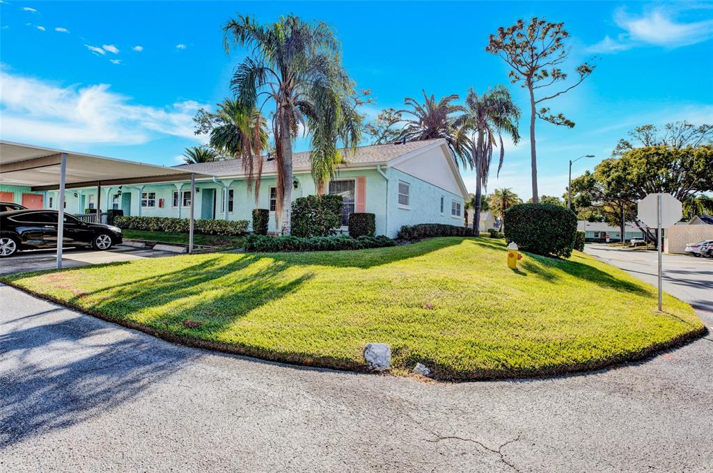 A kitchen with wooden cabinets and a breakfast bar overlooks an entryway with exposed beams — 2465 NORTHSIDE DRIVE UNIT 1808, CLEARWATER, FL