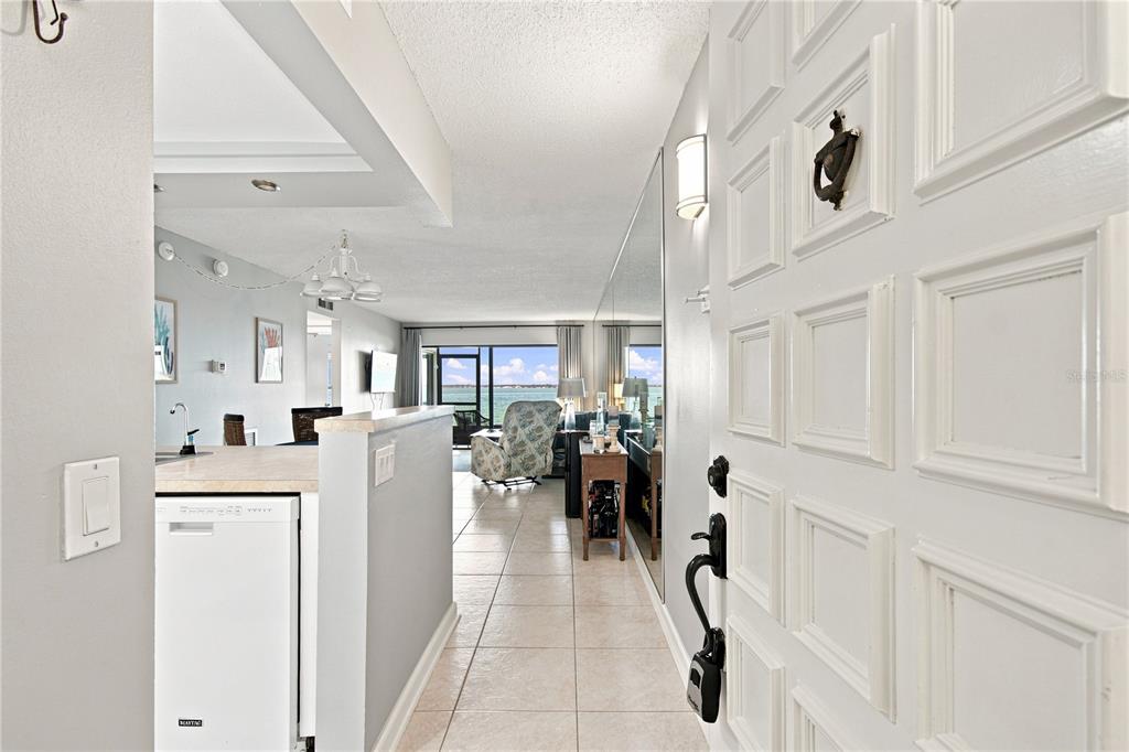 A view from an entryway looking into a kitchen and living area with water views — 6177 SUN BOULEVARD UNIT 109, ST PETERSBURG, FL