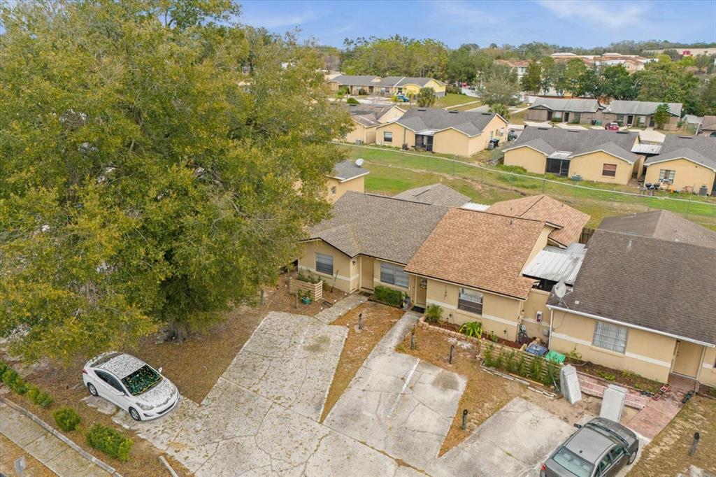 An aerial view shows two attached single-story homes with concrete driveways and a large tree — 1267 WOODMAN WAY, ORLANDO, FL