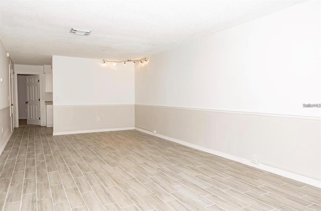 A living room with tile flooring, a large beige sofa, and a coffee table — 1267 WOODMAN WAY, ORLANDO, FL