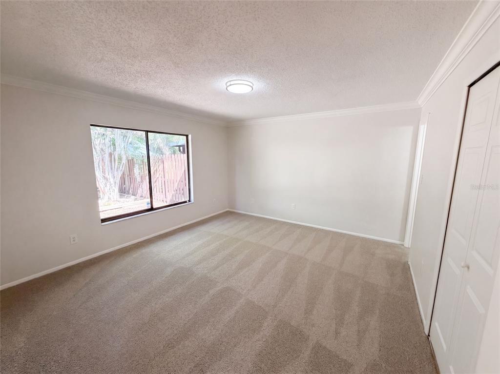 An empty bedroom with beige carpet, white walls, a ceiling light, and a window — 190 PINE KNOLL COURT, CASSELBERRY, FL