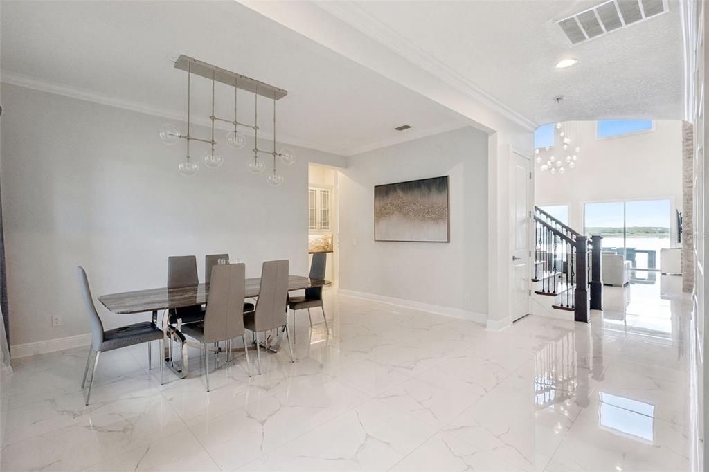 A dining room with a marble floor, a modern chandelier, and a view of stairs — 7693 GREEN MOUNTAIN WAY, WINTER GARDEN, FL