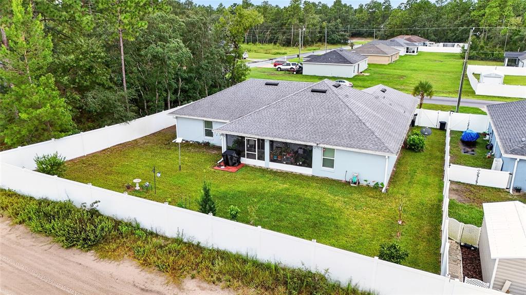 A living room features light blue walls, a gray sofa, a dark armchair, and a fireplace — 15329 SW 65TH TERRACE ROAD, OCALA, FL