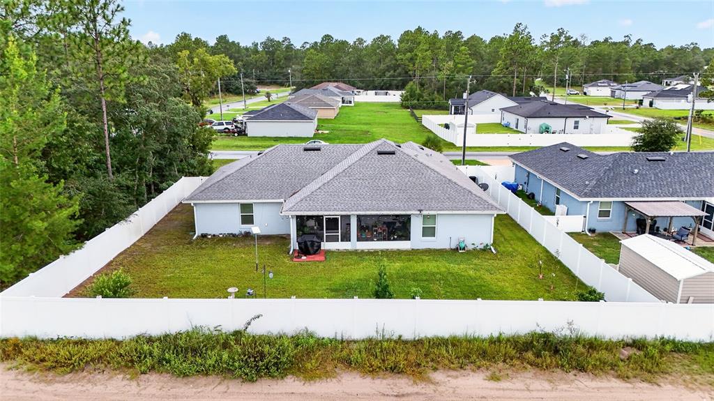 A living room features light blue walls, wood-look flooring, a fireplace console, and a rug — 15329 SW 65TH TERRACE ROAD, OCALA, FL