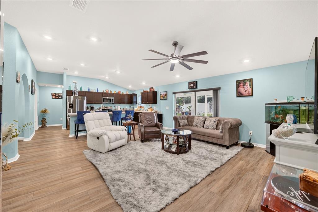 A kitchen features dark cabinets, a central island with blue stools, and light-colored countertops — 15329 SW 65TH TERRACE ROAD, OCALA, FL