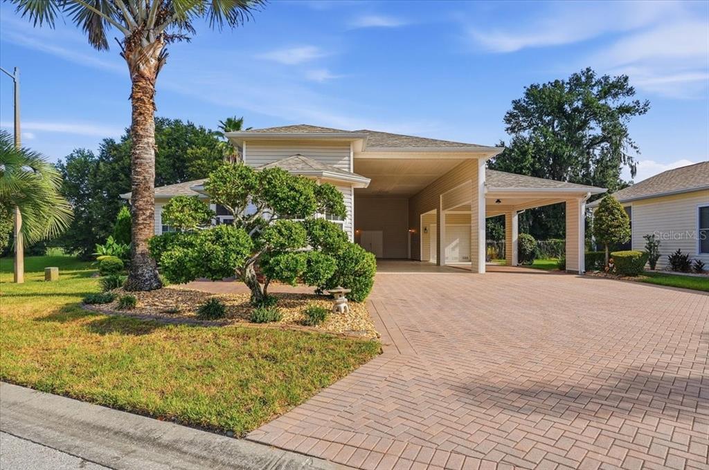 A beige house with a large brick driveway and a covered carport area — 194 LAYNEWADE ROAD, POLK CITY, FL