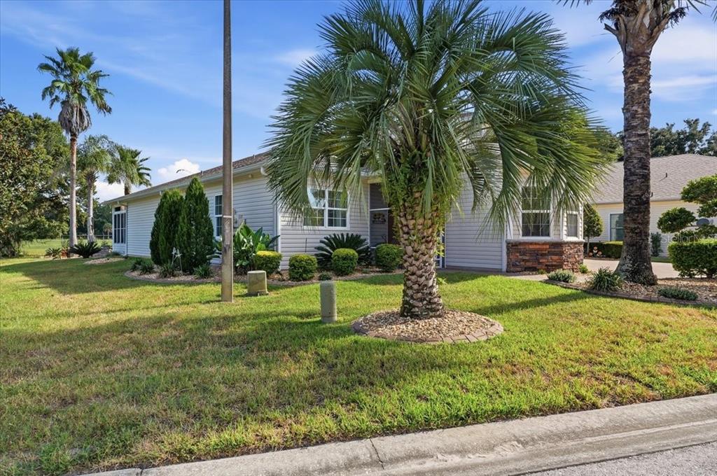 A single-story house with light siding, a palm tree in the front yard, and landscaping — 194 LAYNEWADE ROAD, POLK CITY, FL