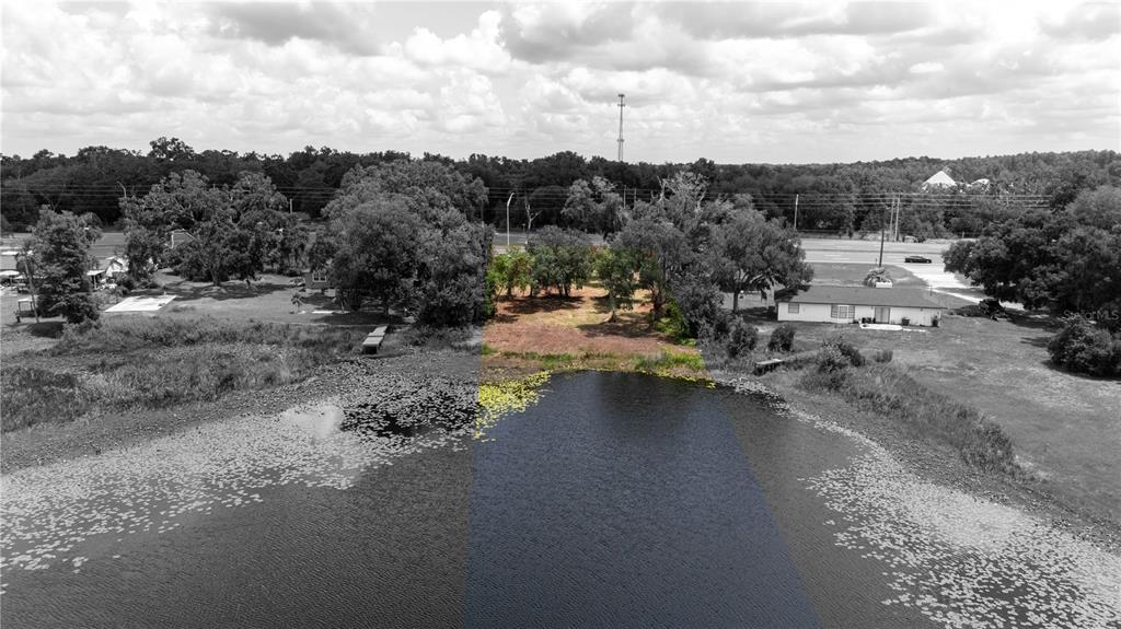 An aerial view shows a waterfront lot with trees and a small house nearby — 0 STATE ROAD 52, LAND O LAKES, FL