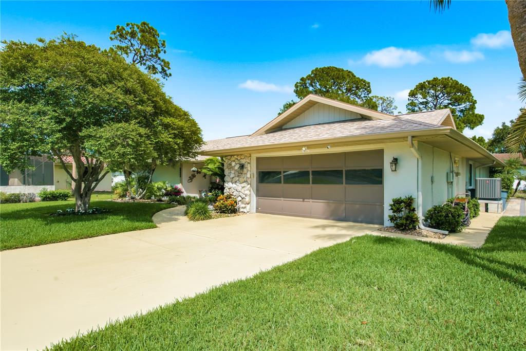 A single-story house with a two-car garage, stone accents, and a concrete driveway — 5468 NIMITZ ROAD, NEW PORT RICHEY, FL