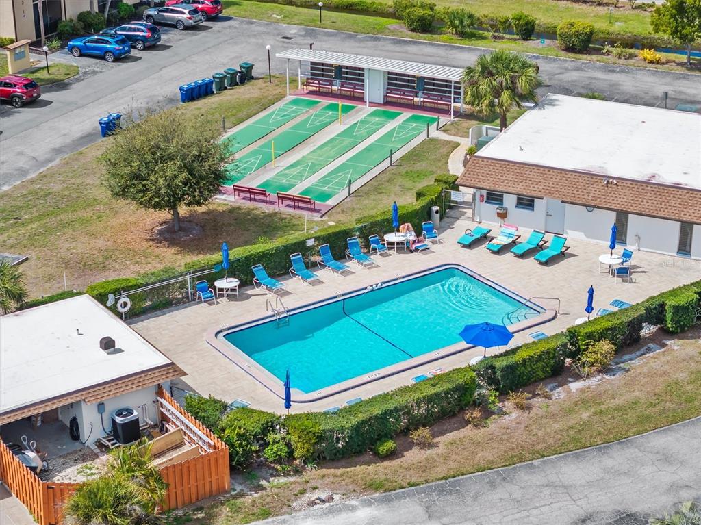 An aerial view shows a swimming pool, shuffleboard courts, and a parking lot — 2 QUAILS RUN BOULEVARD UNIT 8, ENGLEWOOD, FL