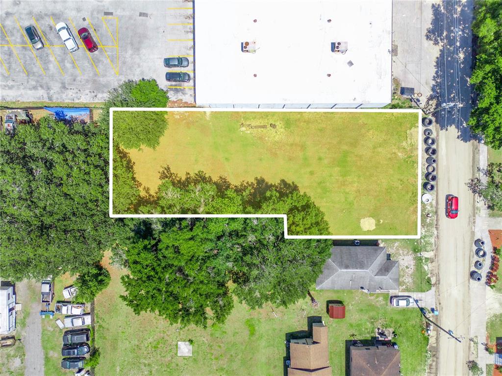 An aerial view shows a rectangular vacant lot outlined in white next to a building — LANIER AVENUE, FORT MEADE, FL