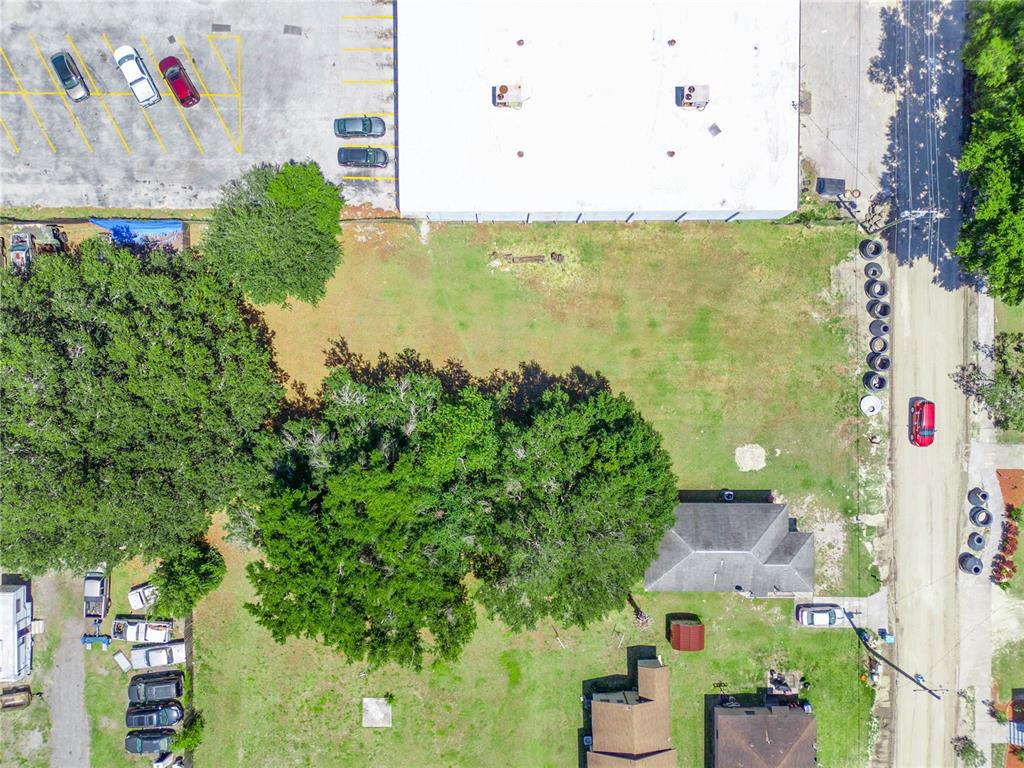 An aerial view shows a vacant grassy lot situated between a commercial building and houses — LANIER AVENUE, FORT MEADE, FL