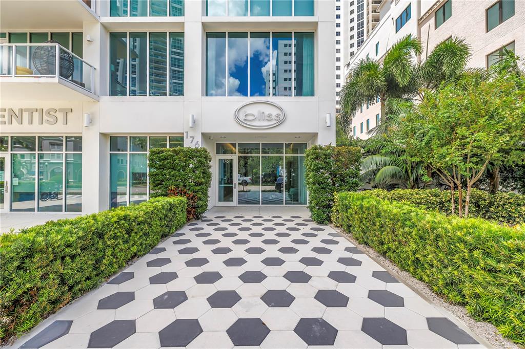 The exterior of a modern building features a patterned walkway leading to a glass entrance — 176 4TH AVENUE NE UNIT 1101, ST PETERSBURG, FL