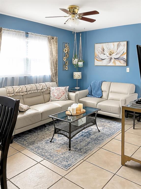 A living room features light-colored sofas, a glass-topped coffee table, and blue walls — 1014 ROOSEVELT AVENUE, BROOKSVILLE, FL