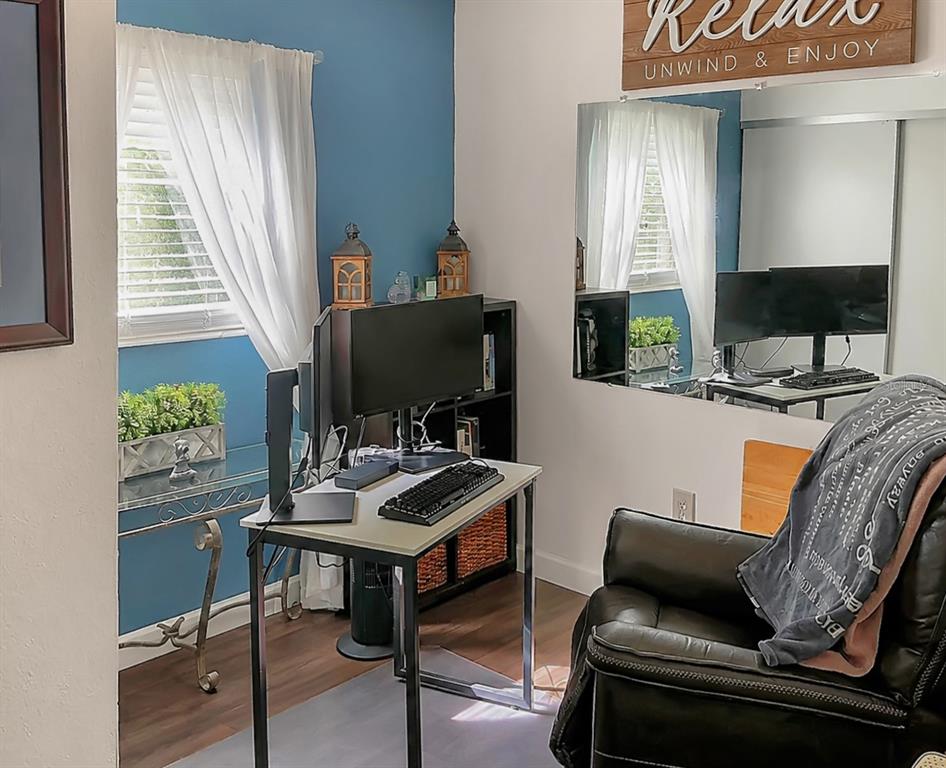 A home office features a desk with a computer, a leather chair, and a blue wall — 1014 ROOSEVELT AVENUE, BROOKSVILLE, FL