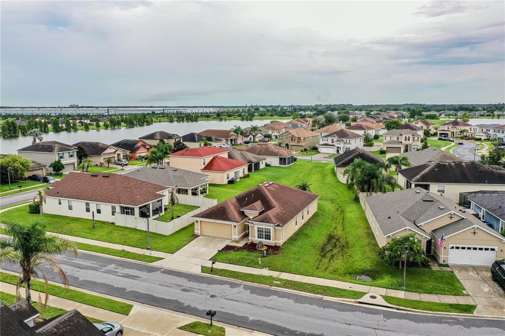 A single-story tan house with a two-car garage and a brown shingled roof — 6015 CHAMPLAIN PASS, LAKELAND, FL