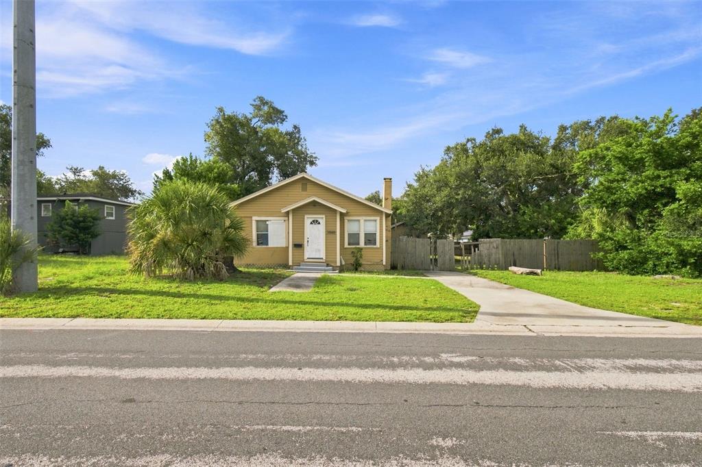 A single-story yellow house with a front porch and a concrete driveway sits on grass — 2848 EMERSON AVENUE S, ST PETERSBURG, FL