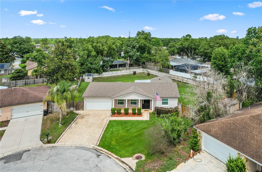 An aerial view shows a single-story house with a paved driveway and a grassy yard — 110 DEVON COURT, LONGWOOD, FL