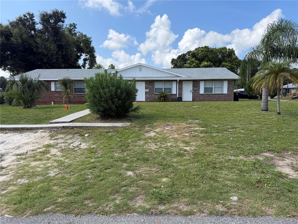A single-story brick duplex with a gabled roof and a large front lawn — 1804 3RD COURT SE UNIT C, WINTER HAVEN, FL