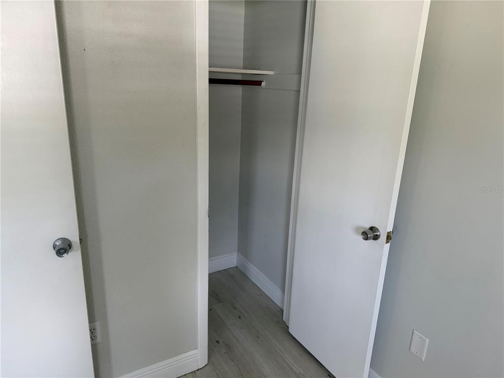 A closet with a shelf and hanging rod sits between two white doors — 1804 3RD COURT SE UNIT C, WINTER HAVEN, FL