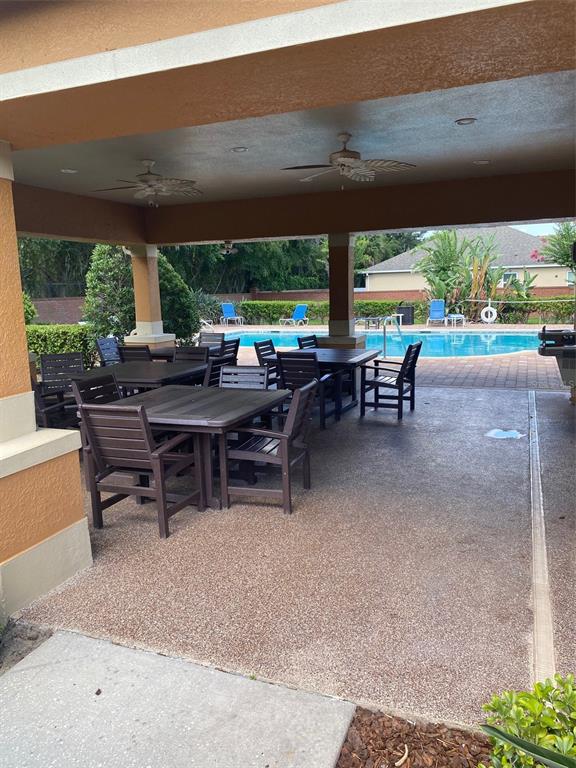 A covered outdoor patio with dining tables and chairs overlooks a swimming pool — 2130 PINE OAK TRAIL, SANFORD, FL