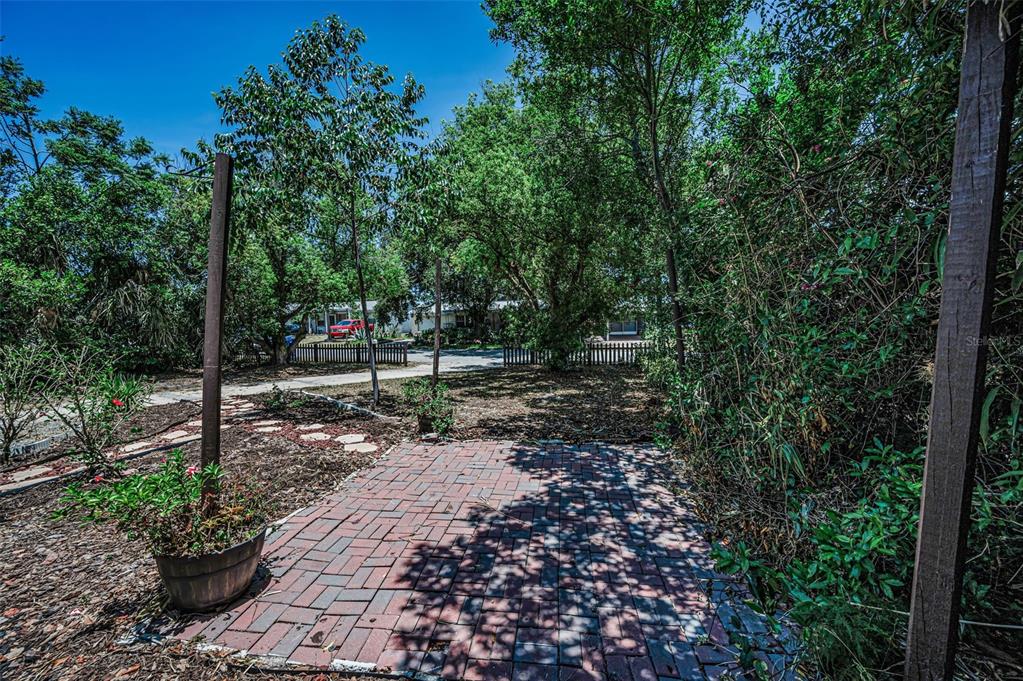 A single-story house with a white stucco exterior, a brick patio, and a wooden arbor — 4312 BEACON SQUARE DRIVE, HOLIDAY, FL