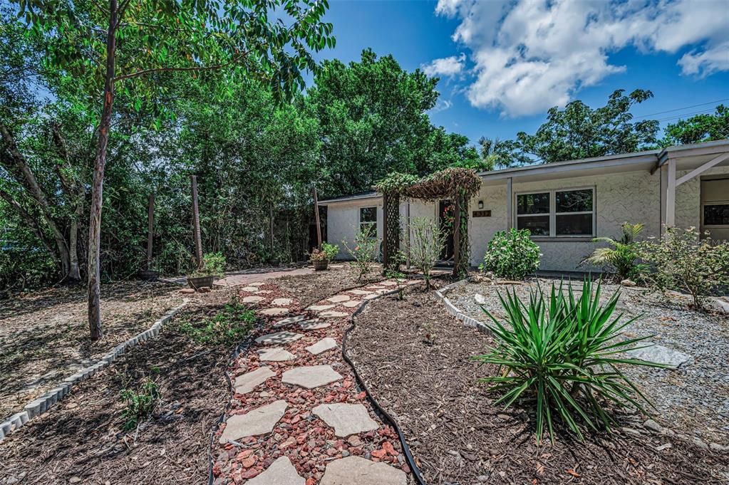 A single-story house with a white exterior, a concrete driveway, and a stone walkway — 4312 BEACON SQUARE DRIVE, HOLIDAY, FL