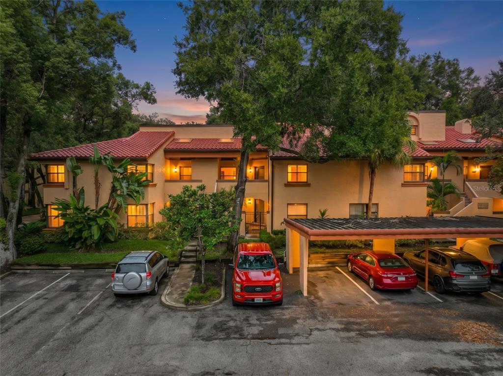 A multi-story tan stucco apartment building features a staircase leading to an upper-level walkway — 1211 SALERNO COURT UNIT 1211, ORLANDO, FL