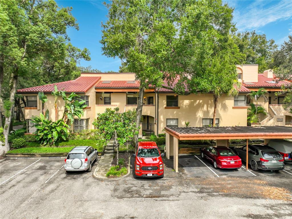 A kitchen features white cabinets, stainless steel appliances, a granite-topped island, and dark wood flooring — 1211 SALERNO COURT UNIT 1211, ORLANDO, FL