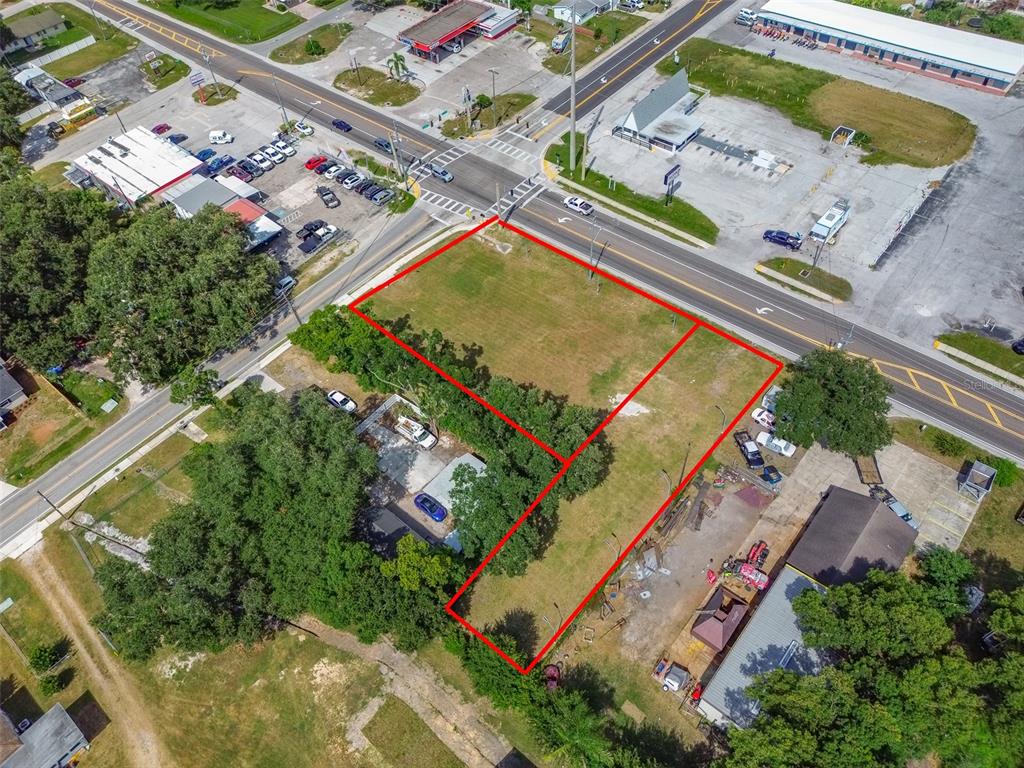 An aerial view shows a vacant, rectangular lot outlined in red near a road intersection — 1336 N COMBEE ROAD, LAKELAND, FL