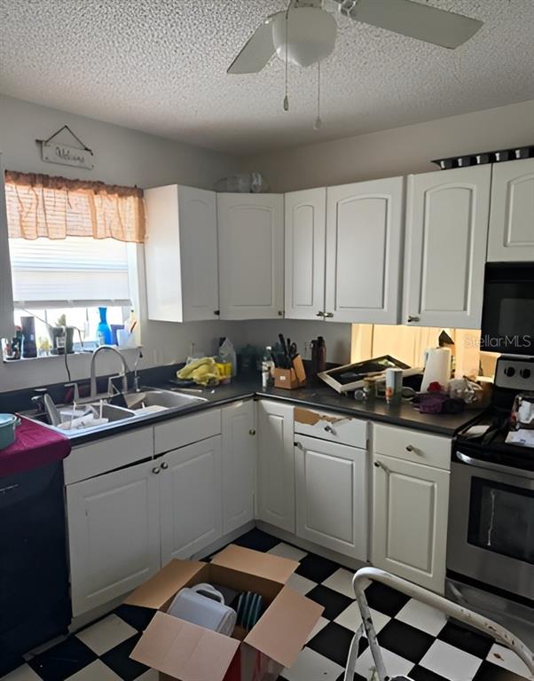 A kitchen features white cabinets, dark countertops, and a black-and-white checkered floor — 101 WALKER DRIVE, INTERLACHEN, FL