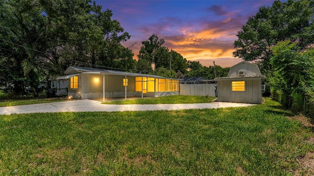 A kitchen features white cabinets, a quartz countertop island with a sink, and a window — 212 KAYLOR DRIVE, AUBURNDALE, FL