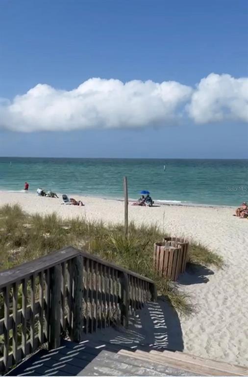 A wooden staircase leads down to a sandy beach with people and ocean views — 12152 JUDSON AVENUE, PORT CHARLOTTE, FL