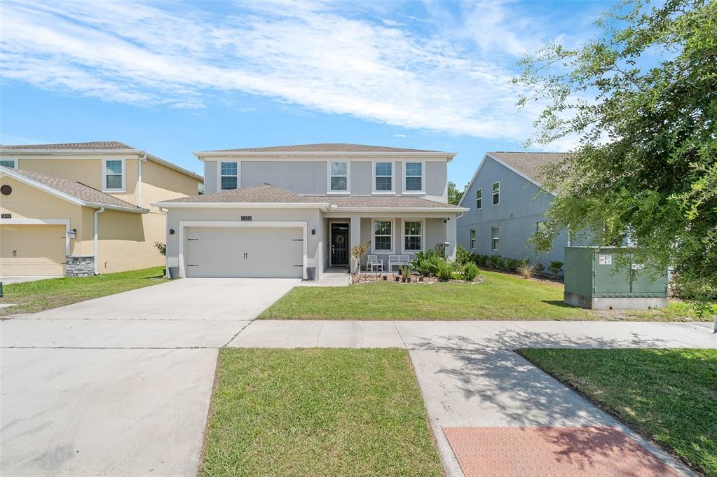 A two-story suburban house with a gray exterior, a two-car garage, and a front lawn — 2353 CRESCENT MOON STREET, KISSIMMEE, FL