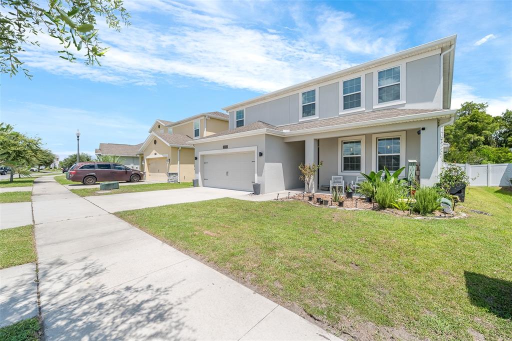 A two-story suburban house with a gray exterior, a two-car garage, and a front lawn — 2353 CRESCENT MOON STREET, KISSIMMEE, FL