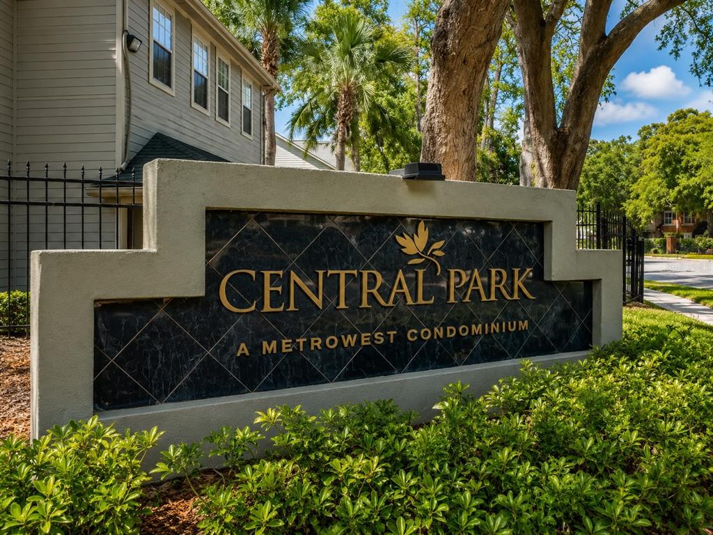 A stone monument sign for Central Park A Metrowest Condominium stands before a residential building — 5980 WESTGATE DRIVE UNIT 201, ORLANDO, FL
