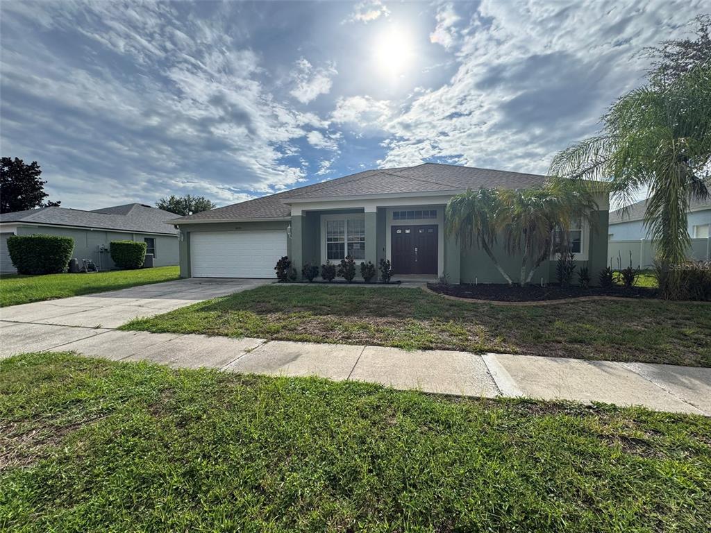A single-story house with a two-car garage, a palm tree, and a concrete driveway — 5035 ALDERBROOK, LAND O LAKES, FL