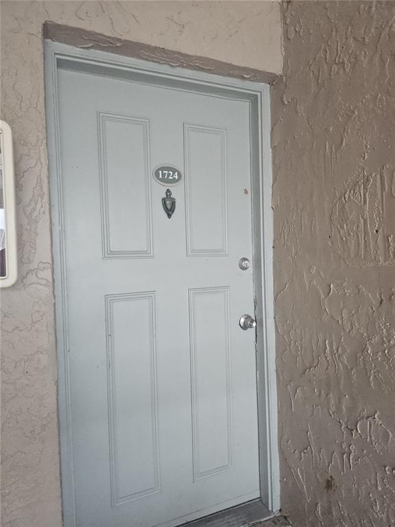 A light gray four-panel front door with a door knocker and unit number 1724 — 7210 N MANHATTAN AVENUE UNIT 1724, TAMPA, FL