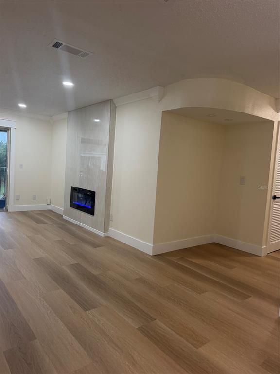 A living room features light wood flooring, a fireplace with a stone surround, and recessed lighting — 7210 N MANHATTAN AVENUE UNIT 1724, TAMPA, FL