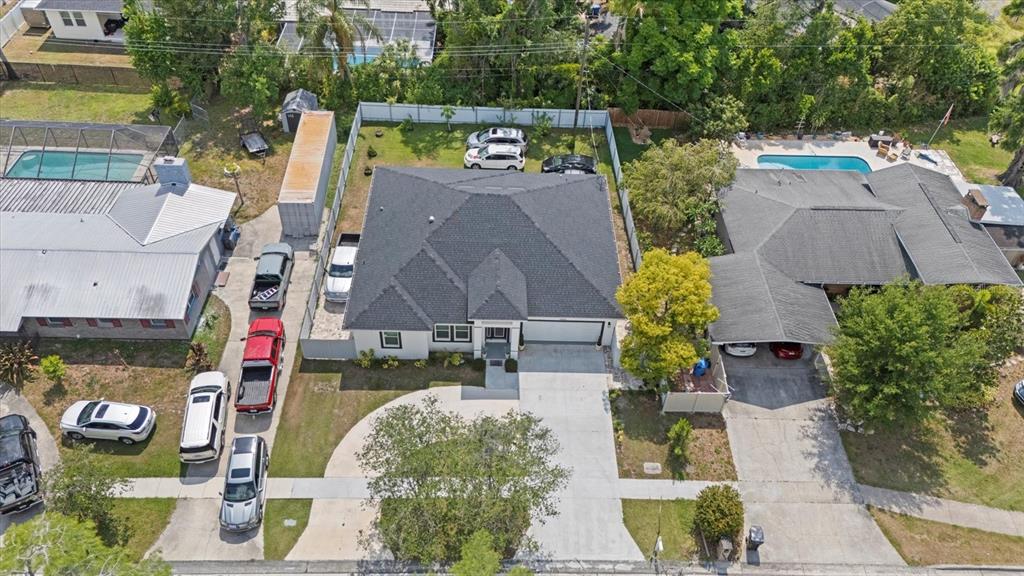 An aerial view shows a residential house with a dark roof, driveway, and swimming pool — 19212 SUNLAKE BOULEVARD, LUTZ, FL