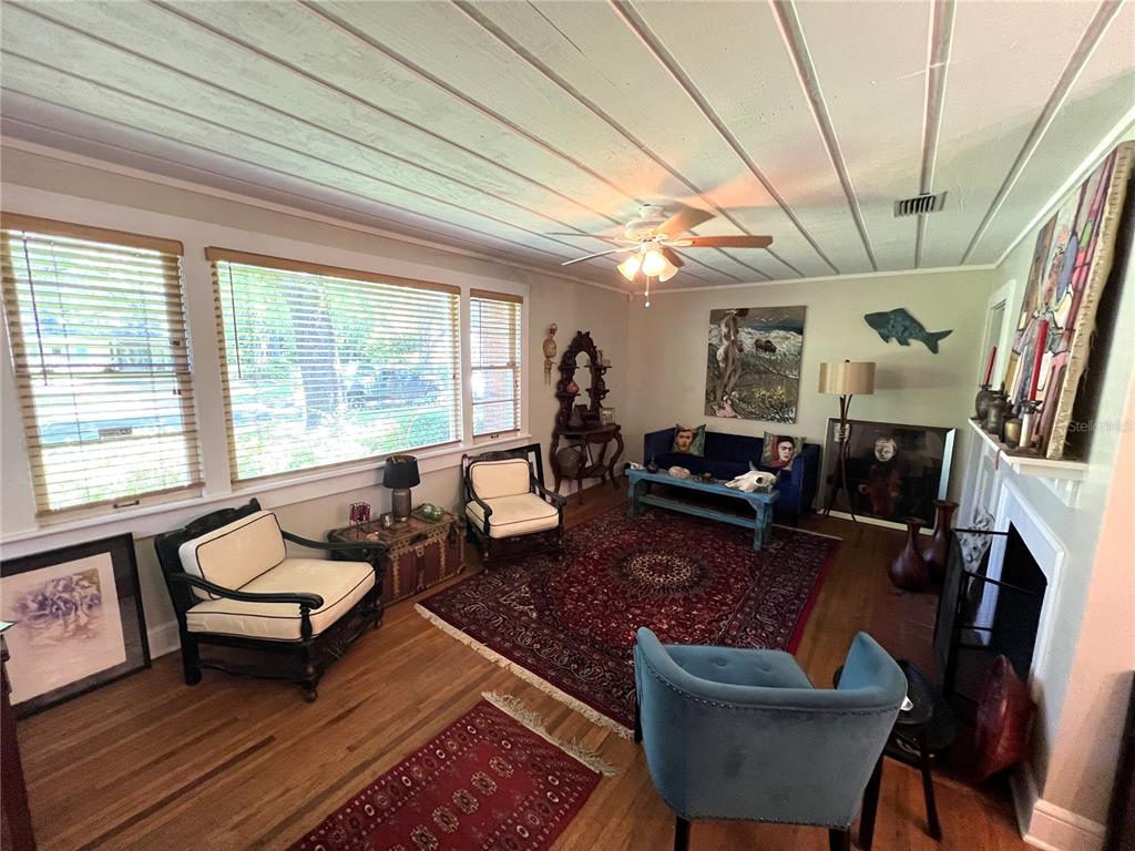 A living room features hardwood floors, a large red area rug, and a fireplace — 1617 NW 7TH PLACE, GAINESVILLE, FL